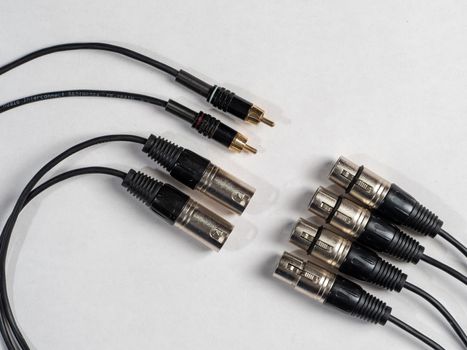 various audio connectors with cables on white background