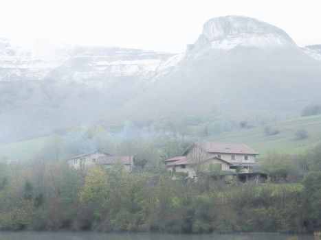 winter landscape with snowy mountains and house with fireplace