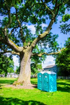 Two blue - white portable toilet cabins at outside event
