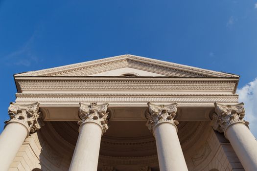 Capitol classical facade with columns on blue sky background. Bottom view