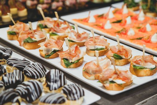 Tasty snacks with salted salmon and cottage cheese filling on square plate