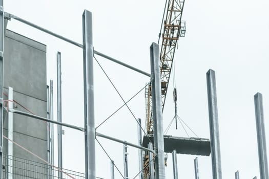 Generic construction site background with scaffolding on the building and crane.