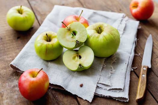 Healthy snack background - red and green apples on rustic wooden background.