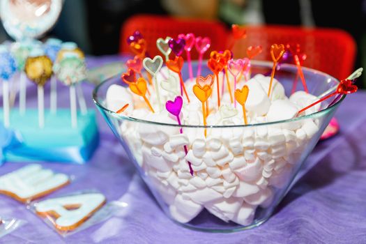 Candy bar on child birthday party. Decorated table with marshmallow for the guests of the ceremony.