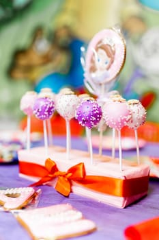 Candy bar on child birthday party. Decorated table with colorful cake pops for the guests.
