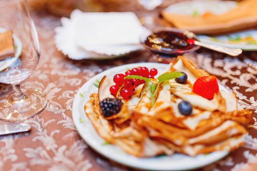 Russian national cuisine - pancakes with fresh berries. Traditional meal for Maslenitsa holiday (Shrovetide, pancake week, carnival).