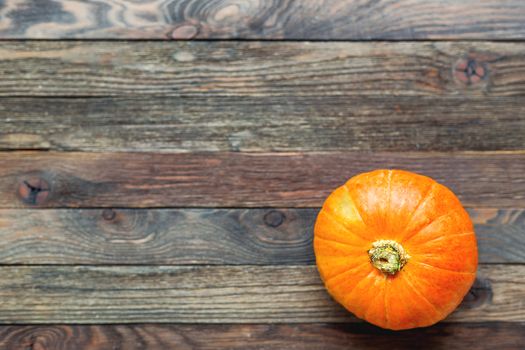 Fresh orange pumpkin. Top view on wooden table. Flat lay.