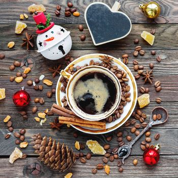 Rustic wooden background with cup of coffee and New Year decorations. Christmas beverage with heart chalkboard. Top view