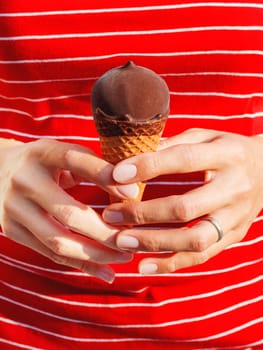 Woman in red shirt is holding ice-cream. Cold dessert. Summer fun.