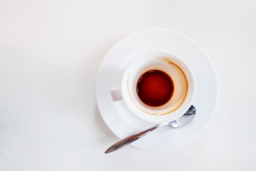 Empty coffee cup on white background. End of coffee break. Coffee grinds in white mug.