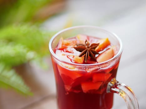 Glass of mulled wine with grapefruit, orange crusts and star anise or illicium seeds. Warming drink with or without alcohol.