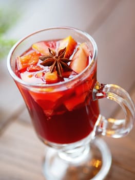Glass of mulled wine with grapefruit, orange crusts and star anise or illicium seeds. Warming drink with or without alcohol.