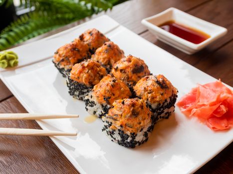 Rolls with eel, shiitake mushrooms, black sesame, spicy sauce, unagi sauce, pickled ginger. Asian cuisine, traditional dish - sushi.