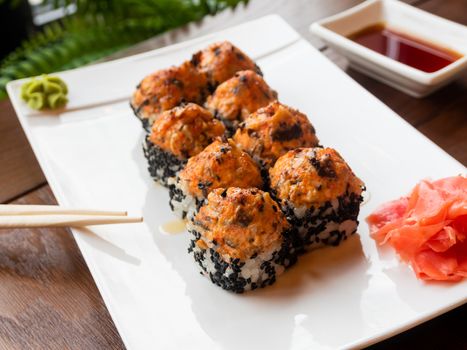 Rolls with eel, shiitake mushrooms, black sesame, spicy sauce, unagi sauce, pickled ginger. Asian cuisine, traditional dish - sushi.