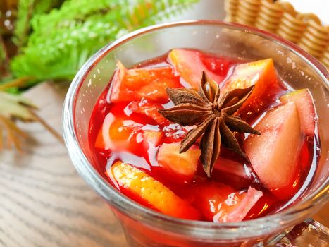 Glass of mulled wine with grapefruit, orange crusts and star anise or illicium seeds. Warming drink with or without alcohol.