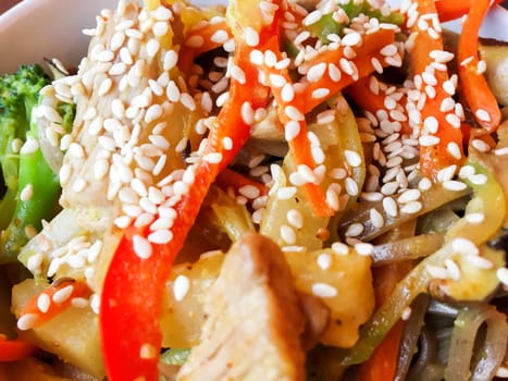 Asian cuisine - noodle in sauce with stir fried vegetables and chicken meat in white bowl. Close up.