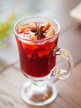 Glass of mulled wine with grapefruit, orange crusts and star anise or illicium seeds. Warming drink with or without alcohol.