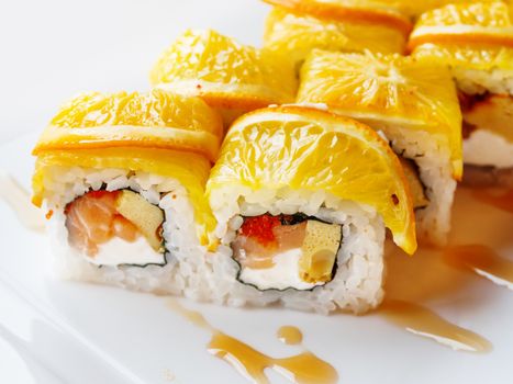 Rolls with rice, seaweed nori, salmon, cream cheese, chicken egg, caviar masago, orange. Marinated ginger and wasabi sauce. Asian cuisine, traditional dish - sushi.