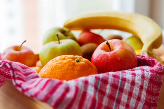 Box full of fresh fruits. Fruit harvest - apples, oranges, lemon, kiwi, banana. Rustic background.