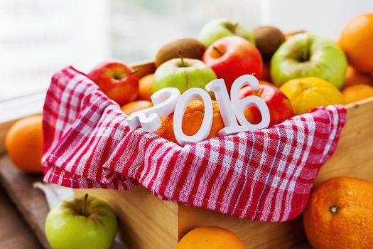 Box full of fresh fruits. Fruit harvest of 2016 year - apples, oranges, lemon, kiwi, banana. Rustic background.