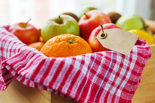 Box full of fresh fruits. Fruit harvest - apples, oranges, lemon. Clear tag for your text.