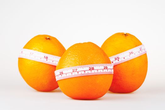 Three oranges with tailor's ruler. Orange diet. Fruit healhy vitamin diet helps to lose weight.