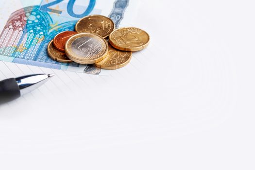 Euro coins and banknotes. European money, official currency of 19 of 28 member states of the European Union. Organizer and pen. Copy space.