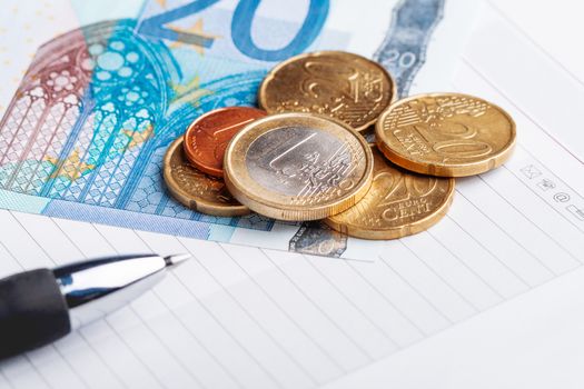 Euro coins and banknotes. European money, official currency of 19 of 28 member states of the European Union. Organizer and pen.