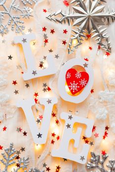 Valentine's Day background with word LOVE, decorations and light bulbs. Red heart - symbol of love.