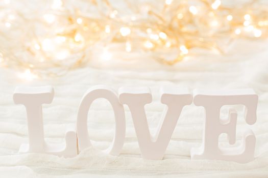 Word LOVE on white background with light bulbs. Can be used as Valentine's Day card.