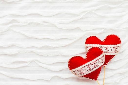 White fabric background with ruche.Two felt hearts with laces, symbol of love. Good for Valentine's Day cards. Place for text.