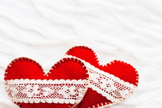 White fabric background with ruche.Two felt hearts with laces, symbol of love. Good for Valentine's Day cards. Place for text.