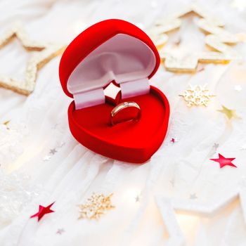 Christmas and New Year holiday background with decorations and engagement ring in gift heart box. Valentine's Day card.