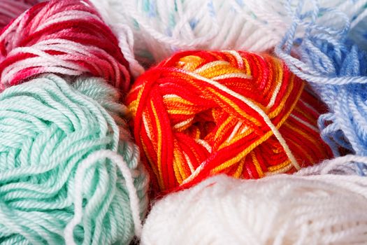 Abstract background with colorful balls of threads. Background with materials for handwork. Hobby of knitting and crocheting.