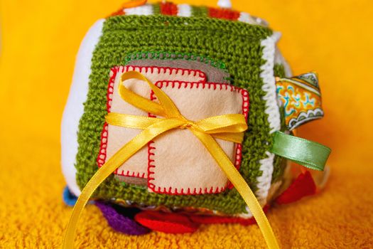 Colorful hand made toy for toddlers and babies. Busy cube. Soft baby block made of fabric to develop skills and fine motor skills. Taggie Cube. Montessori busy toy.