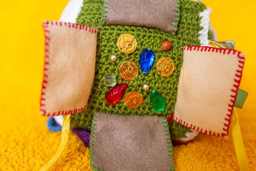 Colorful hand made toy for toddlers and babies. Busy cube. Soft baby block made of fabric to develop skills and fine motor skills. Taggie Cube. Montessori busy toy.
