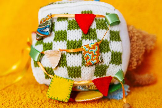 Colorful hand made toy for toddlers and babies. Busy cube. Soft baby block made of fabric to develop skills and fine motor skills. Taggie Cube. Montessori busy toy.