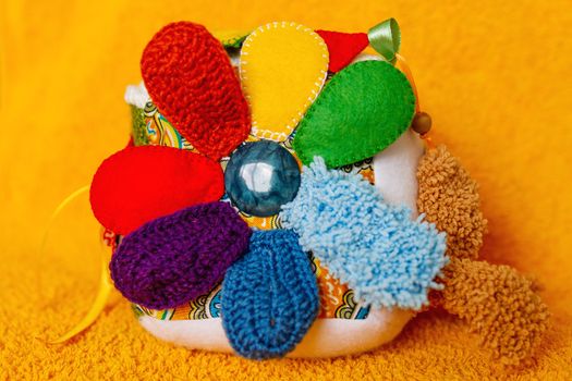 Colorful hand made toy for toddlers and babies. Busy cube. Soft baby block made of fabric to develop skills and fine motor skills. Taggie Cube. Montessori busy toy.