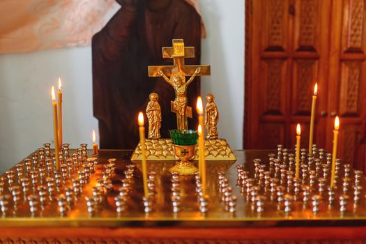 Golden candleholder in Orthodox church. Symbolic Orthodox gold cross with the crucifixion of Jesus.