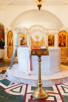 Golden religious utensils - Bible, cross, prayer book, missal, baptismal font. Details in the Orthodox Christian Church. Russia.