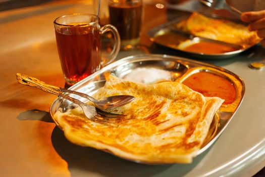 Chapati roti, Indian whole wheat flat bread, with spicy sauce and tea.