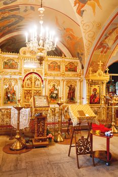 Golden religious utensils - Bible, cross, prayer book, missal, baptismal font. Interoior of Orthodox Christian Church. Russia.