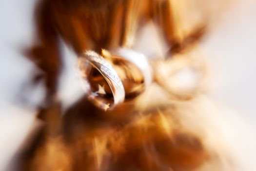 Pair of wedding rings with diamonds on unknown goddess statue. Old rusty metal sculpture captured with Lens Baby Sweet 35mm.
