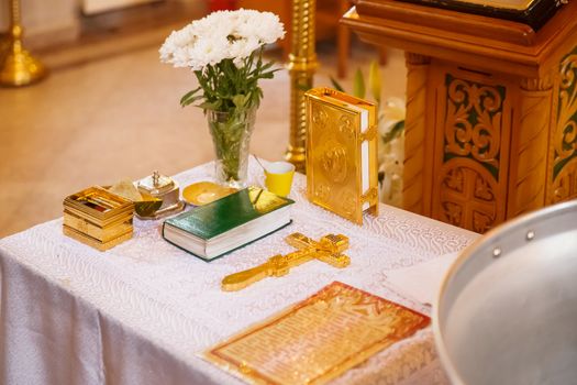 Golden religious utensils - Bible, cross, prayer book, missal. Details in the Orthodox Christian Church. Russia.
