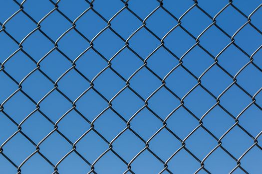 Fence background from metal wire and blue sky