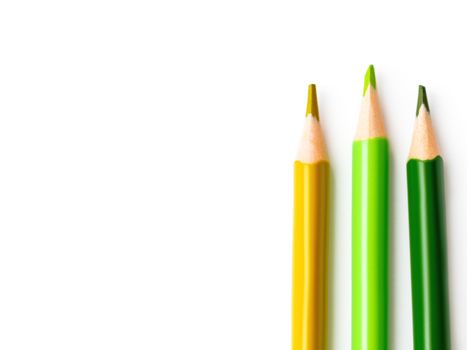 Yellow and green pencils on white background. School supplies with copy space. Kid's stationery. Back to school backdrop.