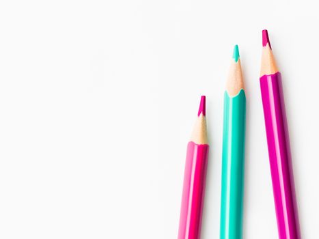 Colorful watercolor pencils on white background. School supplies with copy space. Kid's stationery. Back to school backdrop.