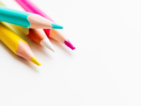 Colorful watercolor pencils on white background. School supplies with copy space. Kid's stationery. Back to school backdrop.