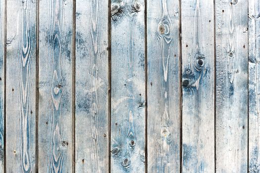 Wooden background of old fence with rusty nails. Shabby texture of blue colored wooden boards.