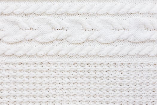 Abstract knitted background. Wool white sweater texture. Close up picture of knitted pattern.
